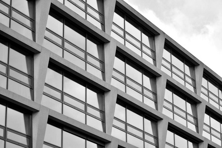 由玻璃和混凝土制成的现代建筑墙的抽象碎片。 黑白的。