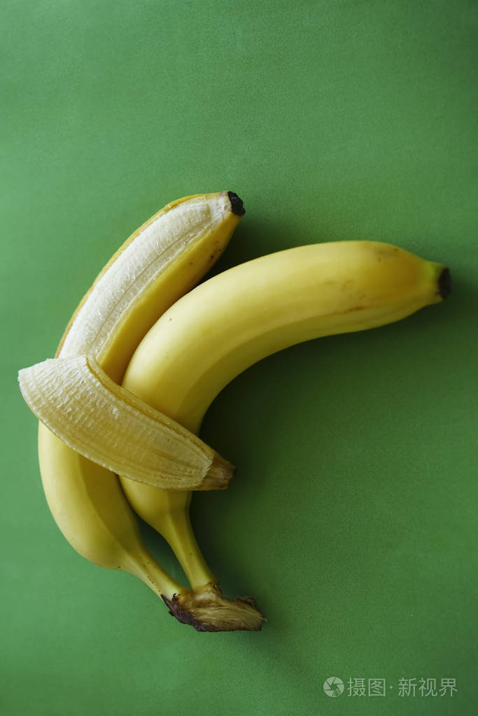 两根香蕉在绿色背景上分离爱和温柔拥抱情侣的符号概念