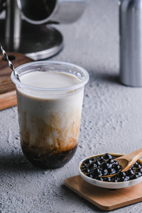 珍珠黑糖与牛奶混合在干净的玻璃中照片