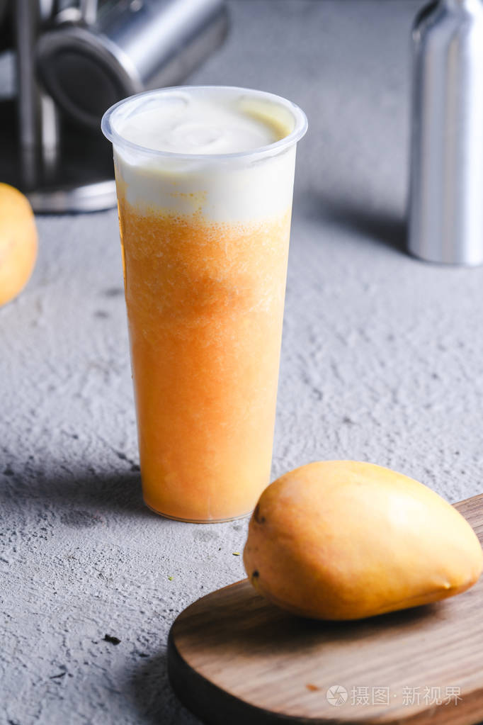 芒果汽水把牛奶盖在干净的玻璃里