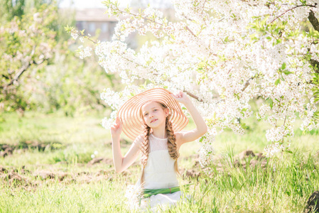 可爱的，梦幻的，蹒跚学步的小女孩走在盛开的春天花园里，庆祝复活节户外活动