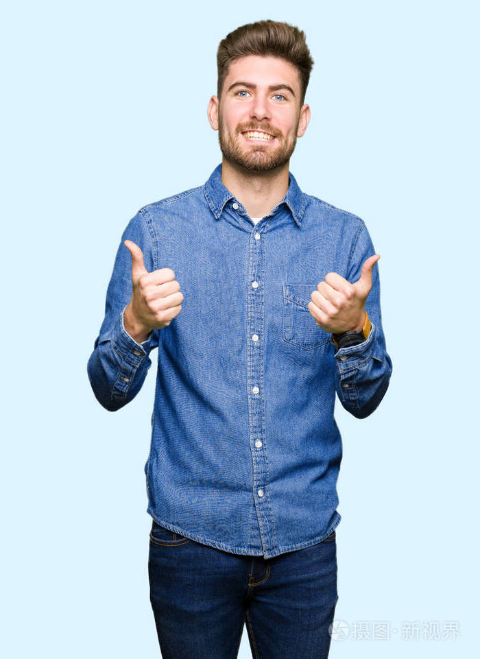 年轻英俊的金发男人穿着休闲牛仔衬衫,成功标志,用手竖起大拇指,微笑