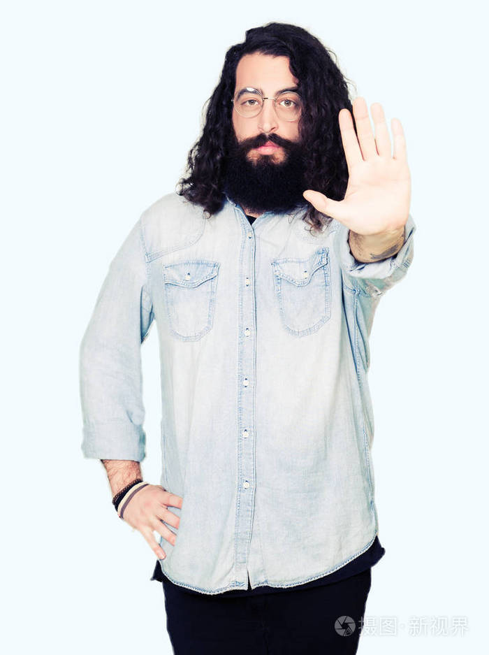 年轻的嬉皮士留着长发和胡须戴着眼镜停止用手掌唱歌警告表情脸上有