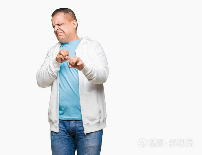中年阿拉伯男人穿着运动衫在孤立的背景下厌恶的表情不高兴和恐惧的做