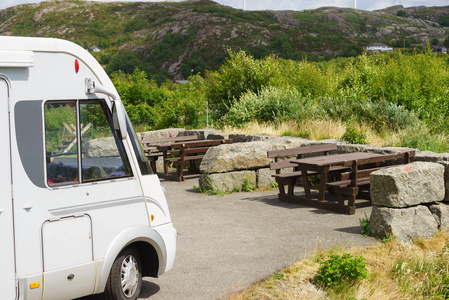 露营车在休息停车区旁边的野餐地点，桌子和长凳，在挪威岩石山自然斯堪的纳维亚欧洲。