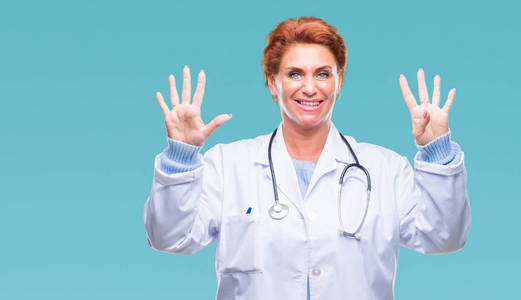 高级白种人医生女士穿着医疗制服，在孤立的背景下，显示和指着第九个手指，同时微笑自信和快乐。
