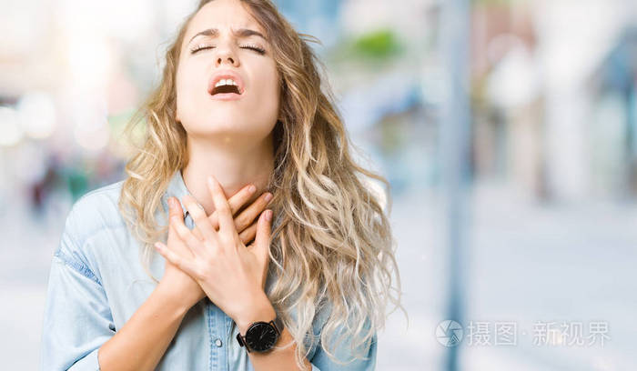 美丽的年轻金发女人在孤立的背景下喊叫和窒息,因为痛苦的窒息.