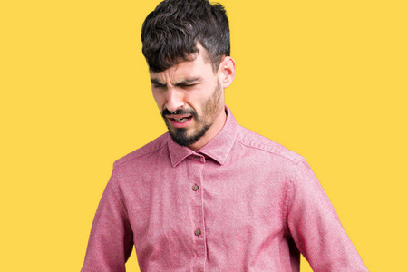 年轻的帅哥穿着粉红色的衬衫，在孤立的背景上，手放在肚子上，因为消化不良，痛苦的疾病，感觉不舒服。 疼痛的概念。