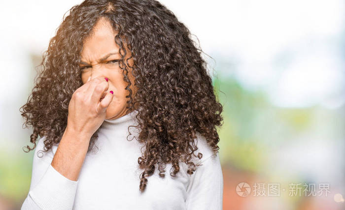 穿着高领毛衣,闻着一些臭味,令人恶心,难以忍受的气味,用手指在鼻子上