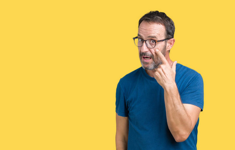 英俊的中年老人戴着眼镜,背景偏僻,眼睛盯着你的手势,可疑的表情照片