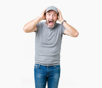 英俊的中年白发苍苍的老人,戴着运动帽,背景孤僻,双手放在头上发疯