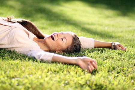 躺在绿色草坪上的年轻女子照片