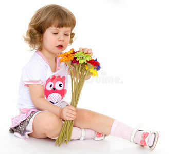 美丽的小女孩拿着一束花。