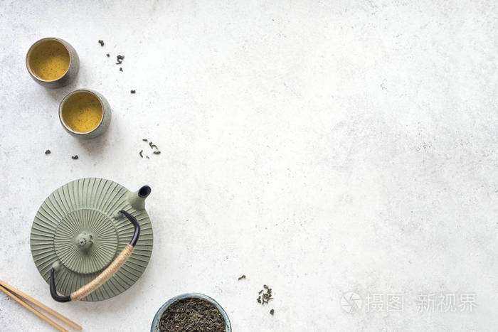 中国茶具铁茶壶和陶瓷茶杯与绿茶和叶子传统茶叶构图在白色背景下复制