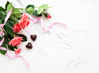 情人节浪漫背景巧克力糖果和大理石背景上的玫瑰