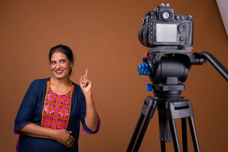 成熟美丽的印度女人在工作室与相机的 vlogs