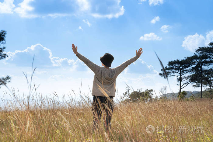 一个人站在大田野里,在美丽的蓝天下享受大自然