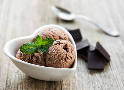 在旧木制背景上放一碗巧克力冰淇淋