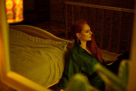 在第比利斯的老阁楼公寓里摆姿势的美丽的红头发年轻女子的复古照片