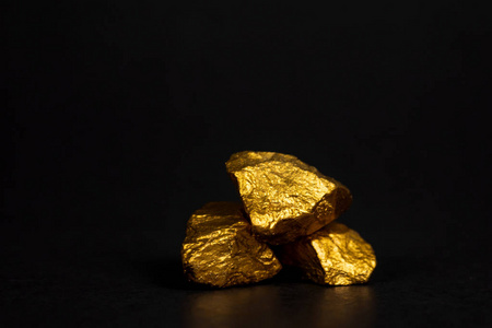 一堆金块或金矿石上的黑色背景宝石或一块金石金融和商业概念.照片
