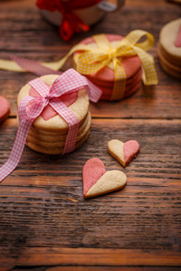 木制桌子上有粉红色丝带的心形饼干