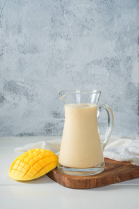 干净茶壶里的芒果混合牛奶照片