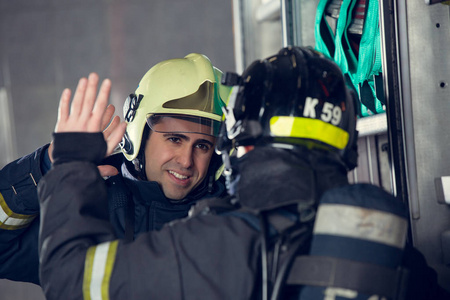 两名消防队员在消防车附近握手的照片照片