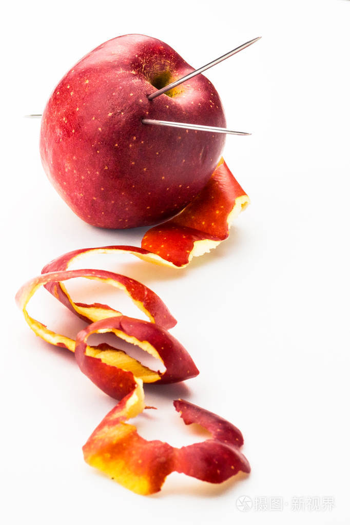 红色成熟苹果在照片上的垂直方向 一个成熟的苹果被针织针刺穿 就像一个线球 苹果的皮肤旁边是一个线仿 编织维生素健康的概念 照片 正版商用图片17hoap 摄图新视界