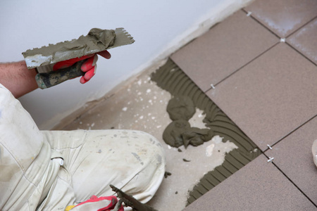 建筑工人用专用手工工具用水泥粘结块均匀地铺在楼梯表面。