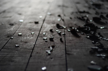 深色木地板上的小碎片玻璃。