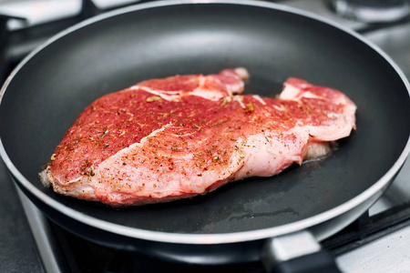 生猪肉剁在煎锅中，加入迷迭香胡椒和盐。