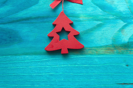 蓝色木质背景上的红色木质圣诞树，有文字空间