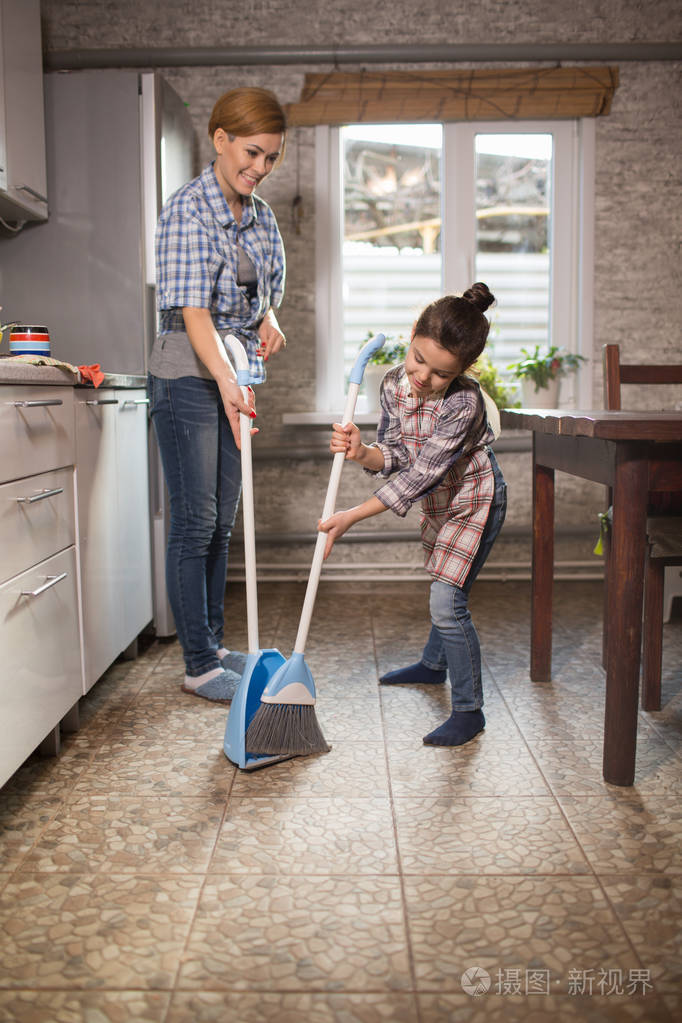 妈妈和女儿正在公寓里打扫卫生,一个女人和一个女孩在做家务