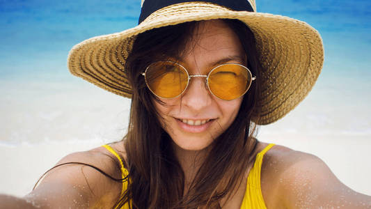 快乐的女孩在假期。年轻的黑发在草帽和太阳镜, 采取自拍