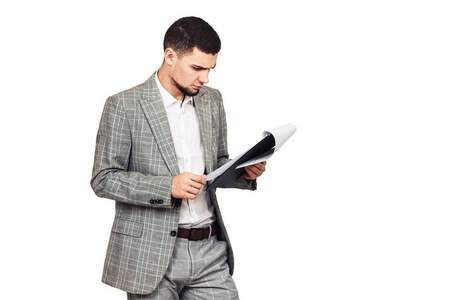 年轻的时尚的家伙在灰色西装与平板电脑在他的手