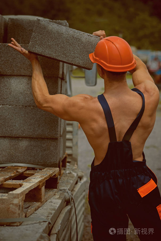 建造者卸载卡车.建筑工人的工作服.建设者运载砖.安全第一