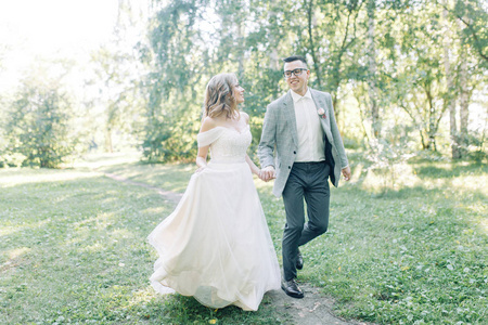 婚礼夫妇正沿着公园散步。 照片拍摄在欧洲风格的自然。