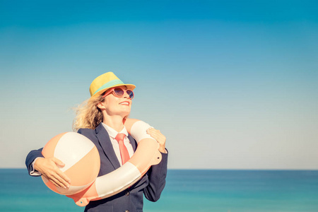 海滩上成功的女商人。 年轻女子在海天的背景下。 暑假和自由旅行概念