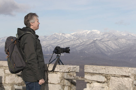 摄影师旅行和拍照。在山上的位置。摄影师拍摄自然与专业相机