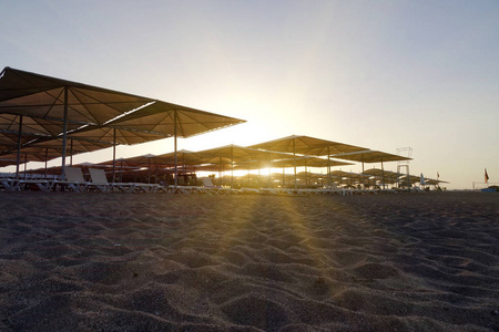 海滩上配有雨伞的太阳椅。旅游业