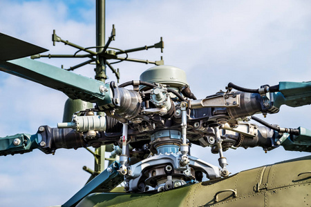 军用直升机特写视图军用直升机旋翼叶片细节特写背景蓝天和云彩照片