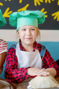 s cap and apron, working with a dough