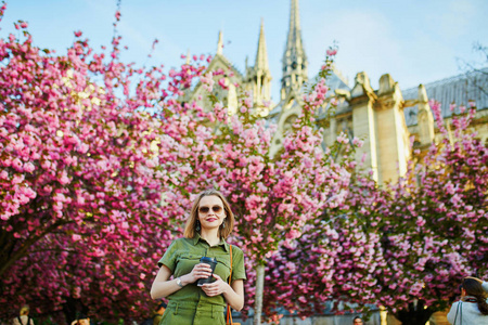 美丽的法国女人在樱花季的春日漫步在巴黎
