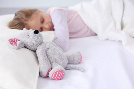 儿童小女孩睡在床上有一只玩具泰迪熊