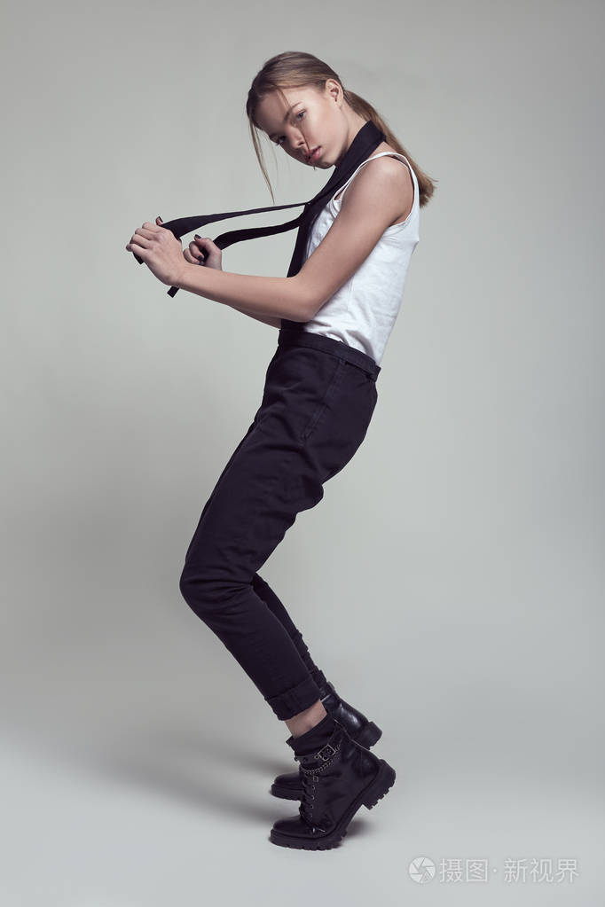 年轻的时尚模特女孩在工作室摆姿势,穿着时尚的衣服.