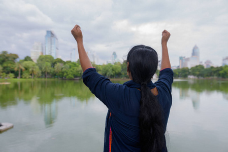 印第安妇女的后方看法与胳膊上升在 lumpini 公园