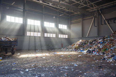 垃圾分类和回收车间与拖车在废物处理厂与阳光. 单独的垃圾收集.