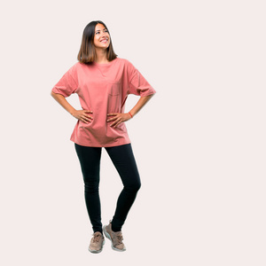 年轻女孩的全身，粉红色衬衫，摆着手臂在臀部。理想的建筑设计用途