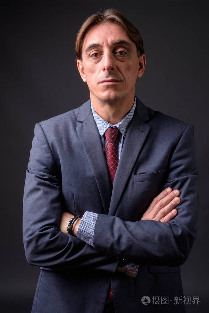 成熟英俊的意大利商人在灰色背景