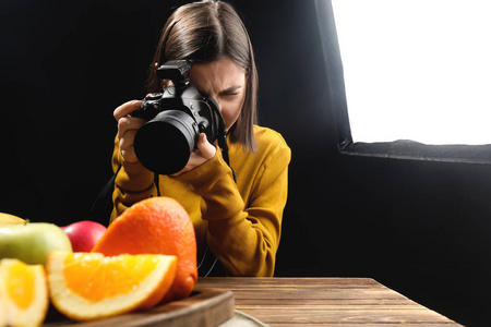 年轻女子在专业摄影棚拍照美味水果
